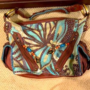 Isabella Fiore beaded fabric back with leather braided strap and leather trim.